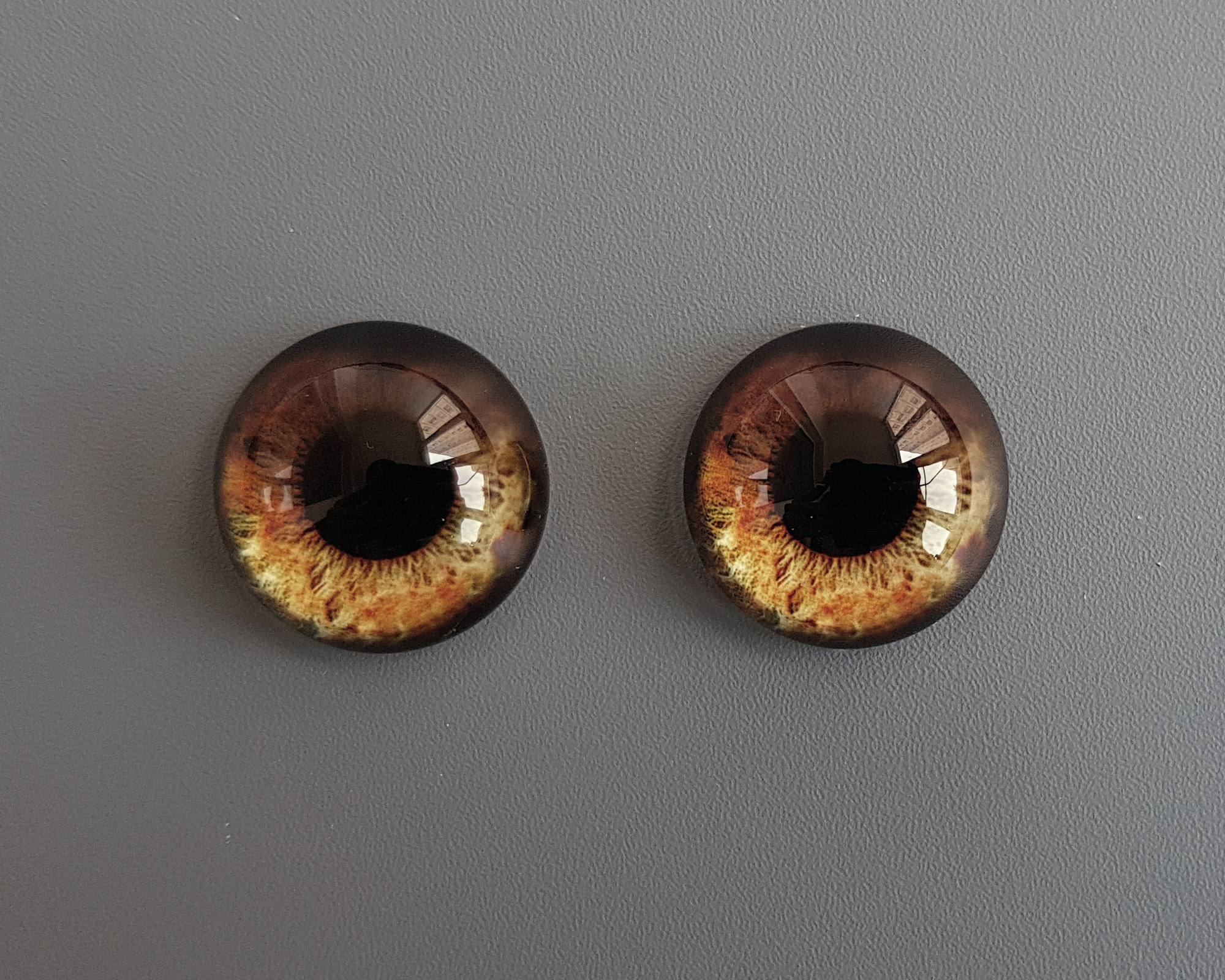 Это реалистичные карие глазки с мягким светлым ореолом по нижнему краю радужки